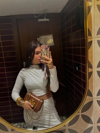 A stylish all-white ensemble with a draped top and matching skirt, perfect for a sophisticated evening.