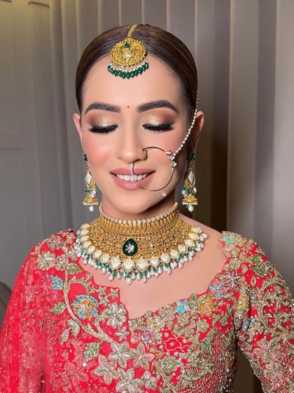 A close-up on the face, showcasing the soft golden shimmer on the eyes and the flawless, glowing skin. This is a perfect example of a soft glam look for a traditional bride.