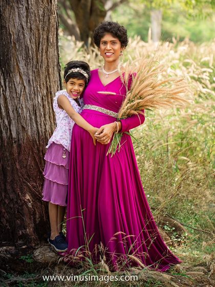 A sweet hug from the big sister-to-be. This outdoor portrait captures the loving bond between mother and daughter in a beautiful, sunlit field.