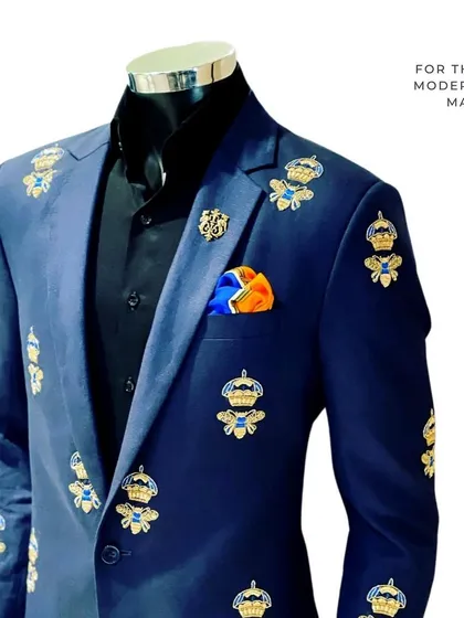 This blue blazer is fit for royalty, featuring intricate embroidery of bees and crowns. It's a bold, contemporary piece for the modern man who wants to make a statement.