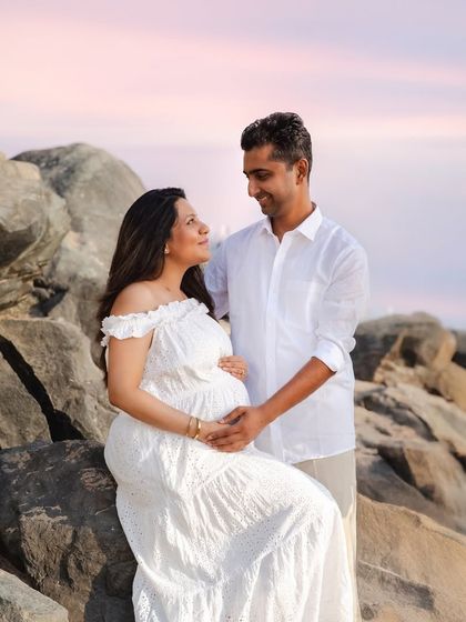 A quiet, loving gaze between partners during a sunset beach shoot. Couple portraits are a beautiful way to celebrate the partnership and teamwork that is at the heart of your growing family.