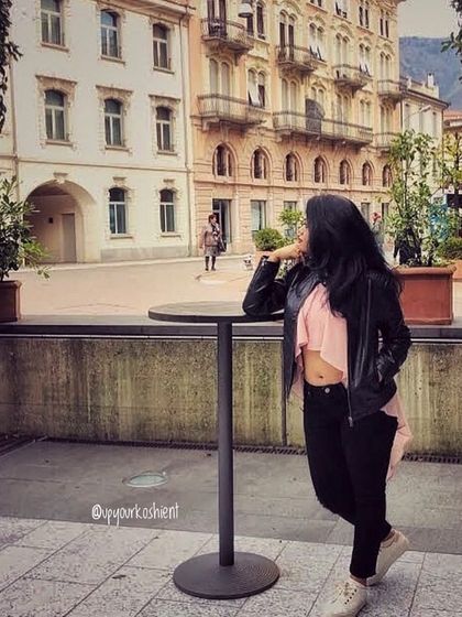 Posing on the streets of Italy. A leather jacket, black jeans, and a stylish pink top create a chic, edgy look perfect for exploring European cities.