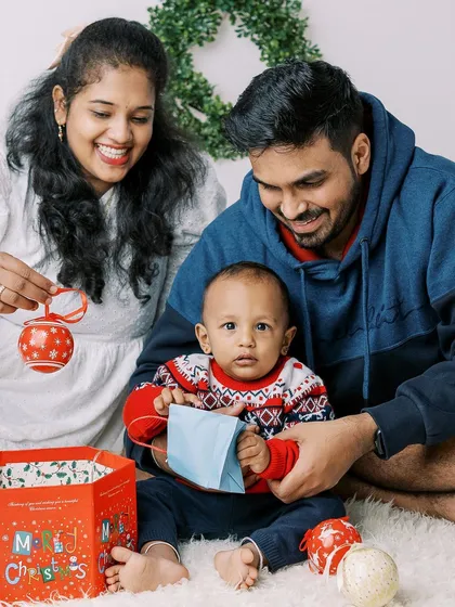 A playful moment from the Christmas mini-session, with the family opening a gift together.