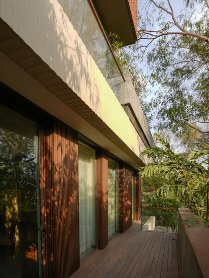 At The Lantern House, stacked terraces and balconies extend the living spaces vertically, inviting greenery and air into every level. The use of natural wood decking and glass railings ensures an uninterrupted connection with the surrounding trees.