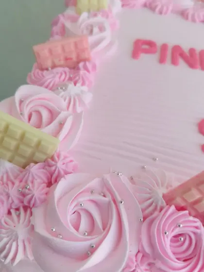 A close-up of the pink and white chocolate bar decorations on the corporate cake.