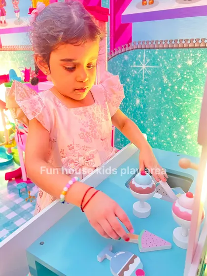 A young girl happily serving up treats from the ice cream cart, fully engaged in pretend play.
