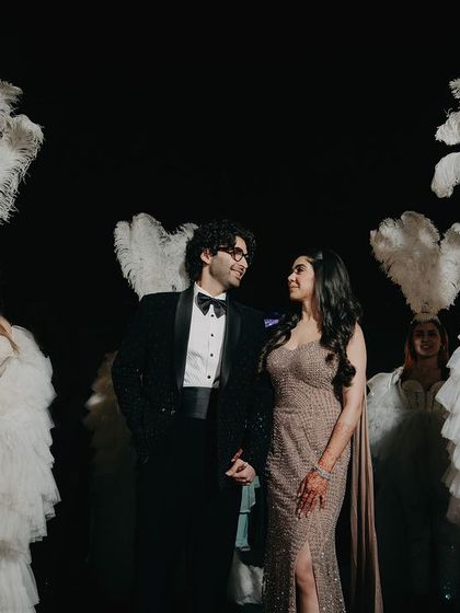 We create theatrical and memorable portraits that match the vibe of your event. Here, the couple is framed by performers in feathered costumes, adding a touch of old-world glamour and spectacle to their engagement photos.