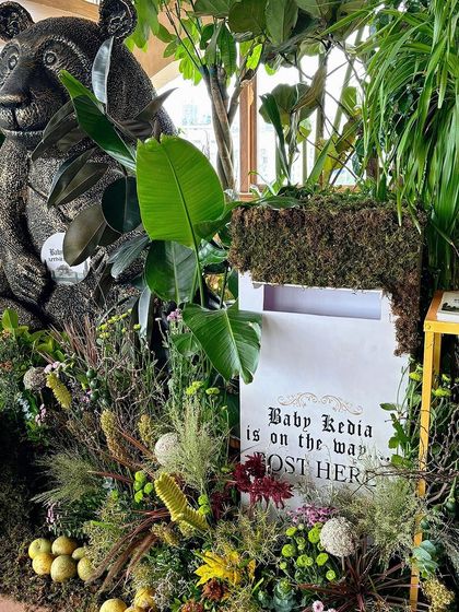 Another view of the bear statue and mailbox, surrounded by lush greenery.