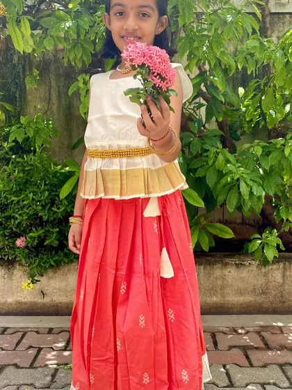 Here is the Nila set, beautifully captured. The peplum top with a traditional Kasavu border and the peach cotton skirt with delicate motifs create an elegant look that's still incredibly comfortable for all-day wear.