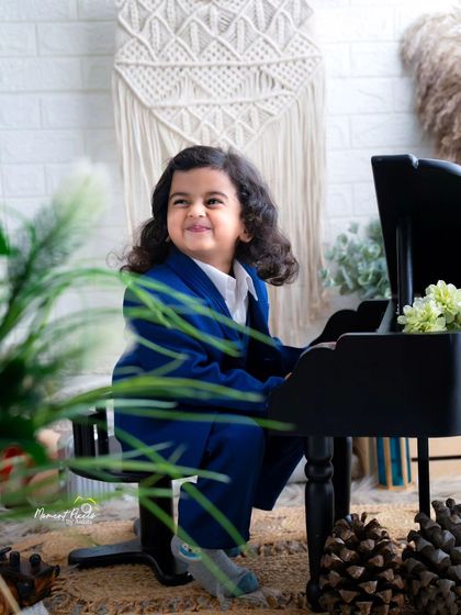 A future maestro at the piano. This little boy's happy, smiling face shows how much fun a toddler photoshoot can be.