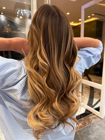 A freehand hair colour balayage with warm, golden blonde tones.