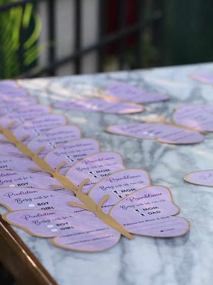 Custom butterfly-shaped wish cards, perfectly matching the 'Baby is Blooming' theme. Guests wrote their predictions and advice for the parents-to-be.