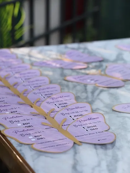 Custom butterfly-shaped wish cards, perfectly matching the 'Baby is Blooming' theme. Guests wrote their predictions and advice for the parents-to-be.