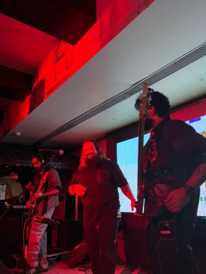 A candid shot of the band on stage at The Stables, bathed in red light. We adapt our energy and look to fit the vibe of any venue.