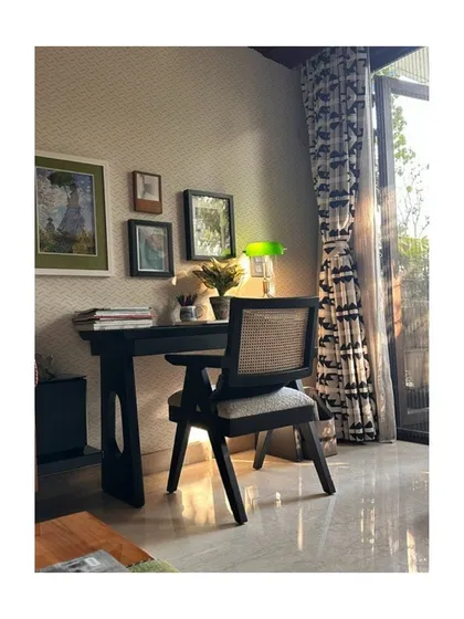 A simple, elegant study corner featuring our version of the Chandigarh chair. Placed by a window with patterned curtains, this space is perfect for focused work, bathed in soft, natural light.