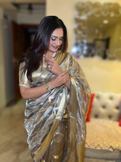 Saree, smile, and a whole lot of sass. This look features a glamorous metallic saree paired with a bold lip and radiant skin.