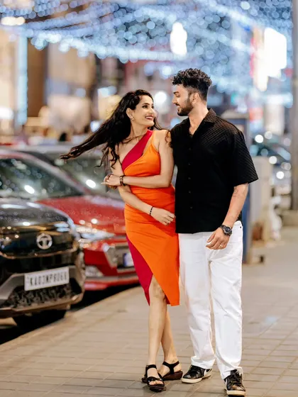 A couple walks down a brightly lit Bangalore street at night, their laughter captured in a candid moment. This photo demonstrates my ability to create vibrant, modern portraits in an urban setting.