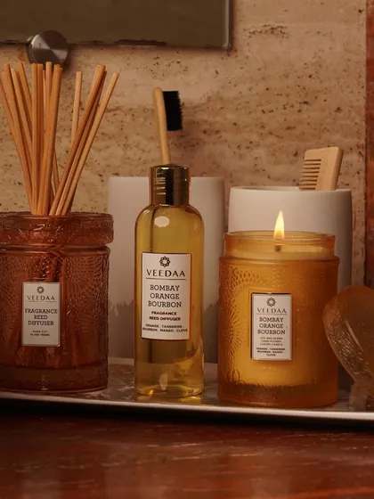 Unleash the warmth of Bombay Orange Bourbon in your bathroom. This image shows our reed diffuser and scented candle from the same fragrance family, creating a cohesive and cozy scent experience.