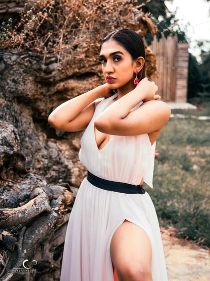 A beautiful and strong pose in a natural setting. The composition is classic, and her expression is confident and serene.