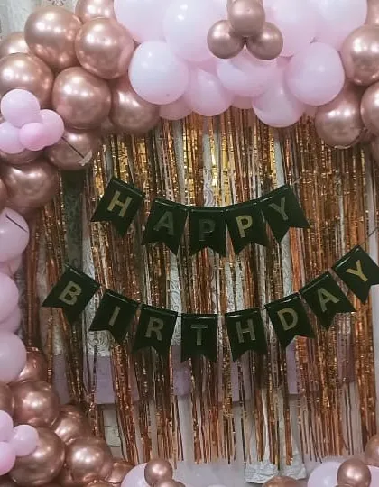 A beautiful rose gold and pink balloon arch against a gold fringe backdrop. This is a classic and popular choice for birthdays and bridal showers.