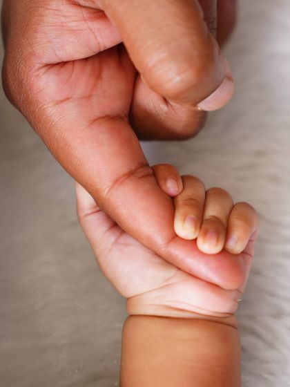 The simple, powerful connection of a baby's hand holding a parent's finger. These are the details that matter most.