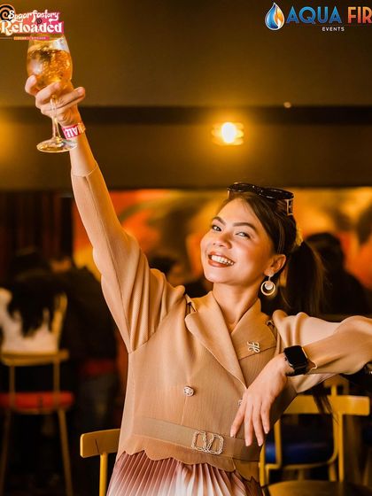 A guest raising a toast to the camera.