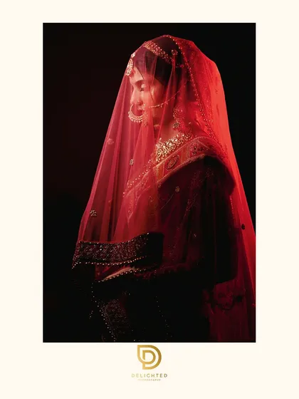 I love creating dramatic bridal portraits that feel timeless and artistic. Using shadow and a single source of light, we captured the bride's serene beauty under her red veil.