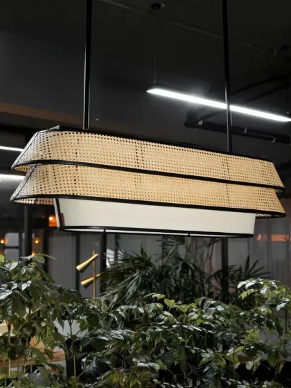 Our modern two-tiered rattan chandelier combines traditional weaving with a sleek, contemporary design. The black metal frame contrasts beautifully with the natural cane webbing, making it a sophisticated statement piece for offices, dining rooms, or hotel lobbies.