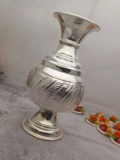 A German silver flower vase with a stand, featuring a modern design with traditional leaf-like engravings.