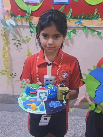 A student proudly displays her 3D model depicting the importance of recycling and protecting the Earth. Our Earth Day activities encourage students to think critically about environmental issues and present solutions creatively.