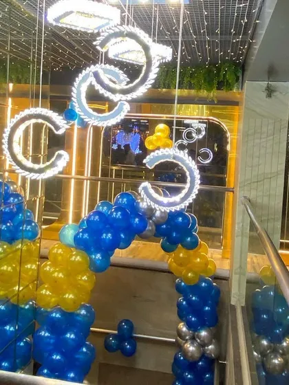 A balloon arch in blue and yellow at the entrance of a venue, setting the stage for a Prince-themed party.
