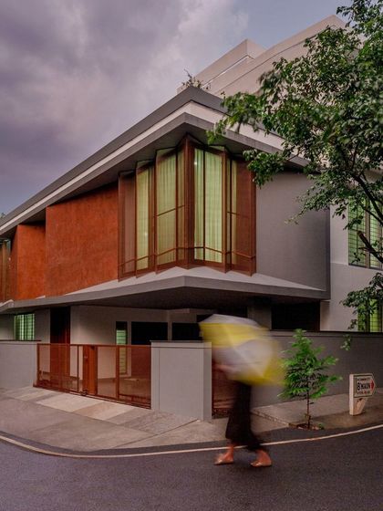 The Copper House is situated on a corner plot in a dense Bangalore neighborhood. Its notched facade, with a mix of copper textures, perforated screens, and glass, is designed to strategically draw in light and air while maintaining privacy.