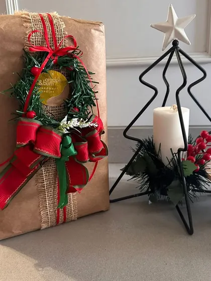 A beautifully wrapped gift next to one of my Christmas tree candle stands. The rustic brown paper and wreath embellishment create a warm, homespun feel.