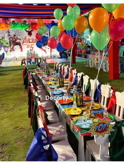 The long kids' table setup in the outdoor party area, ready for a feast for all the little superheroes.