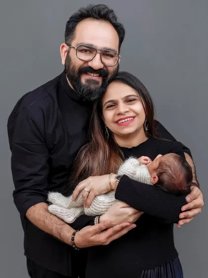The first official family photo. This portrait of new parents with their newborn is a timeless classic, shot against a simple grey backdrop to keep the focus on their new world.