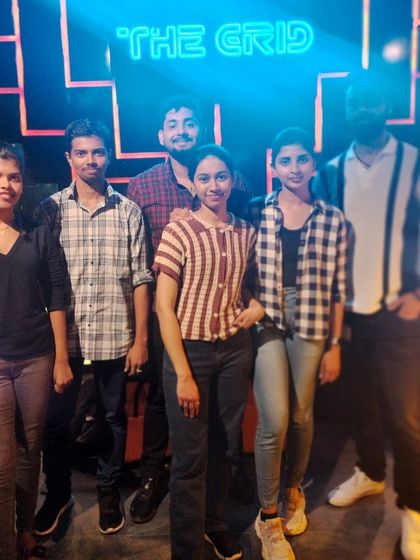 A group of friends posing in front of our iconic neon sign.
