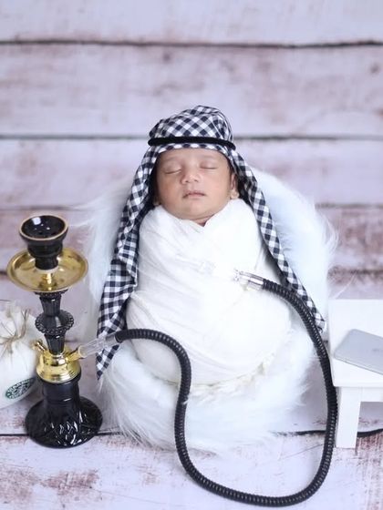 An Arabian Nights inspired theme. This creative setup features a baby dressed as a sheikh with a miniature hookah, perfect for a unique and imaginative portrait.