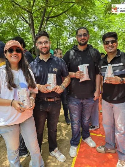 Happy faces from the KPMG team after a successful seed ball making session. They are holding the finished seed balls, ready for dispersal.