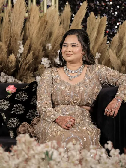 A relaxed, seated portrait of the bride, looking elegant and poised during her sangeet.