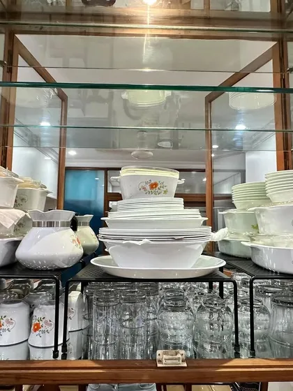 We used shelf risers to organize this beautiful glass crockery cabinet, creating layers to display the dinnerware set while keeping it functional.