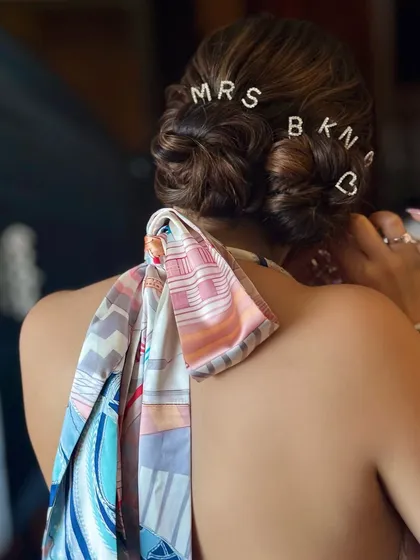 A close-up of the "MRS BKN" custom crystal clips in a messy, chic bun, perfect for a beach party or welcome brunch.