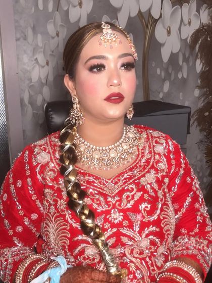 A complete bridal look. Here you can see the beautiful braided hairstyle paired with the classic makeup we did for her. The entire look is a blend of tradition and elegance, perfect for a modern Indian bride.