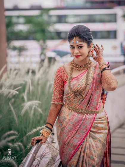 A beautiful portrait of a bride in a traditional saree, posing against an urban backdrop.