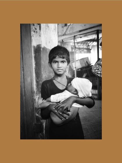 A poignant black and white photograph by a young artist from the "Inheritance" project, capturing a quiet moment of responsibility and care.