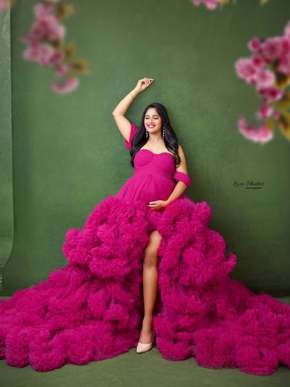 A joyful and energetic pose in a vibrant pink gown. This image captures the pure happiness and excitement of the mom-to-be.