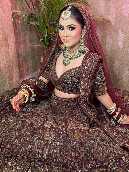 A full view of the stunning maroon bridal lehenga, showing the beautiful flare and detailed embroidery.