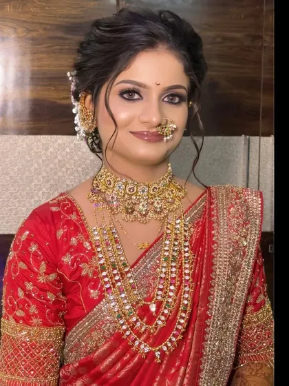 This bride is the picture of elegance in a red Nauvari saree, with a soft, messy bun and beautiful floral accessories.