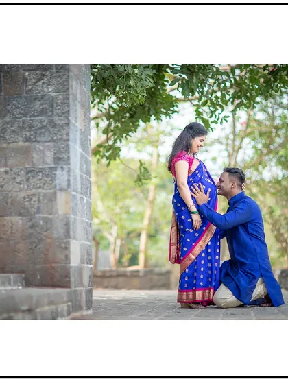 A classic pose of the dad-to-be kissing the baby bump, made even more special with their beautiful traditional outfits.