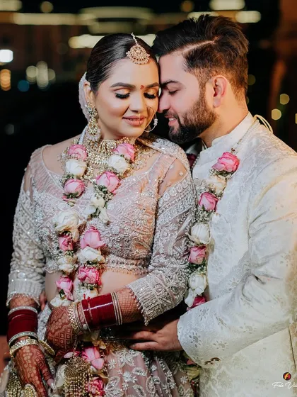 A close and loving embrace between the couple after their wedding ceremony, their floral garlands adding a touch of freshness.