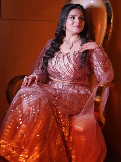 Regal and radiant in a sequined rose-gold gown for her engagement. The makeup features a soft smokey eye and glowing skin.